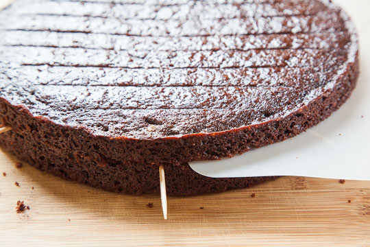 Remove the top layer of the cake using a thin flexible plastic cutting board or a piece of stiff cardboard.