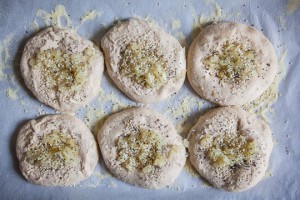 Fill each center of the bialy with cooked onions, poppy and sesame seeds. Sprinkle with salt and pepper. Move them close to the center of the pan. Photo by Irvin Lin of Eat the Love.