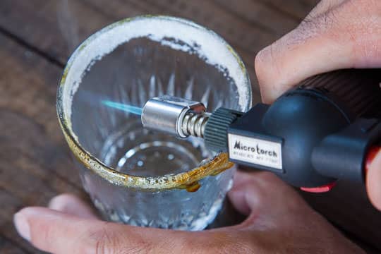 Using a kitchen blowtorch to create a caramel sugar rim on a glass. Photo by Irvin Lin of Eat the Love.