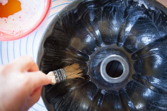 Brush the bundt pan with some of the melted butter before filling it with the Pumpkin Chocolate Monkey Bread. Process photo by Irvin Lin of Eat the Love.