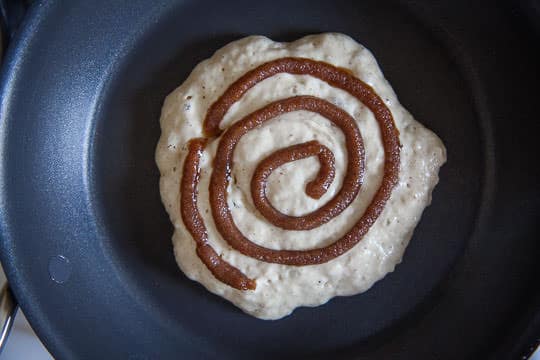 Squeeze a swirl of the cinnamon sugar on top of the pancake batter. Process photo by Irvin Lin of Eat the Love.