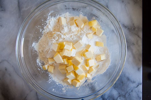 Sprinkle cubes of butter over the dry ingredients.
