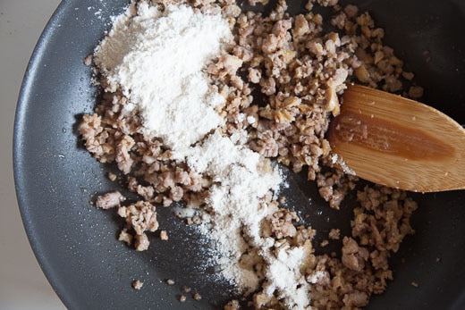 Add the flour to the brown sausage.