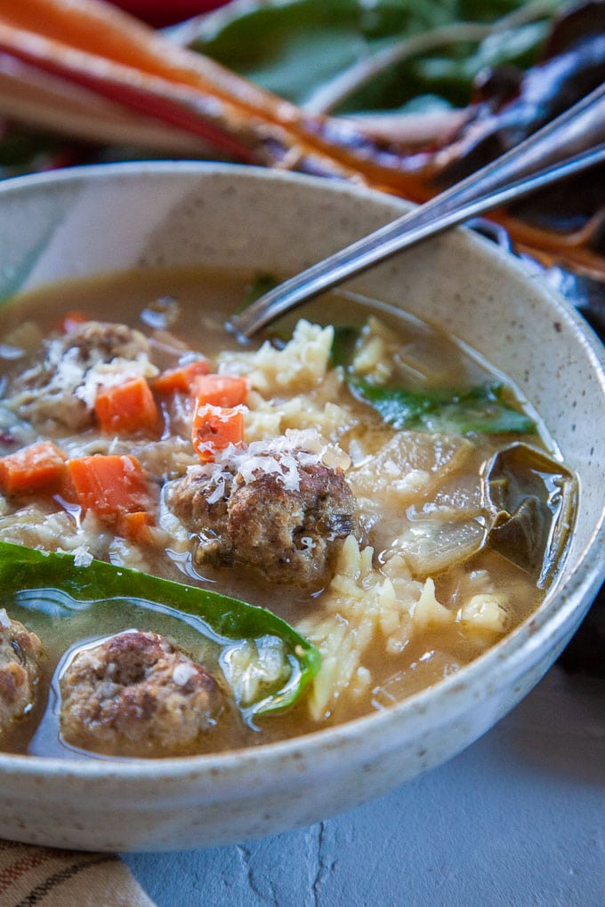 Italian Wedding Soup in a bowl with a spoon in it.
