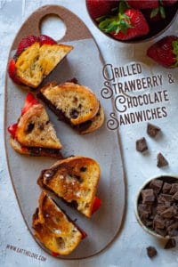 Grilled strawberry and chocolate sandwiches on sourdough crusty bread and a sprinkling of sea salt sitting on a cheeseboard.