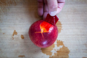 Peel the peach with your fingers, using the X at the bottom of the peach as a starting point