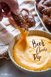 Soft Pretzel being dipped into Beer Cheese Dip