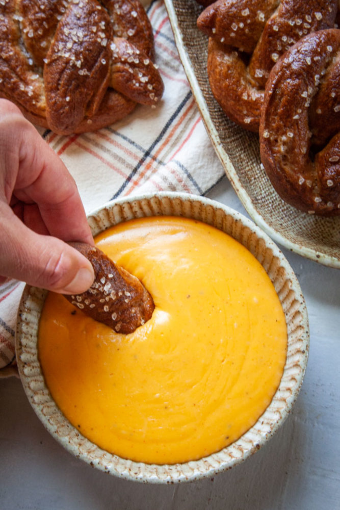 Dipping a rye soft pretzel into a bowl of beer cheese dip