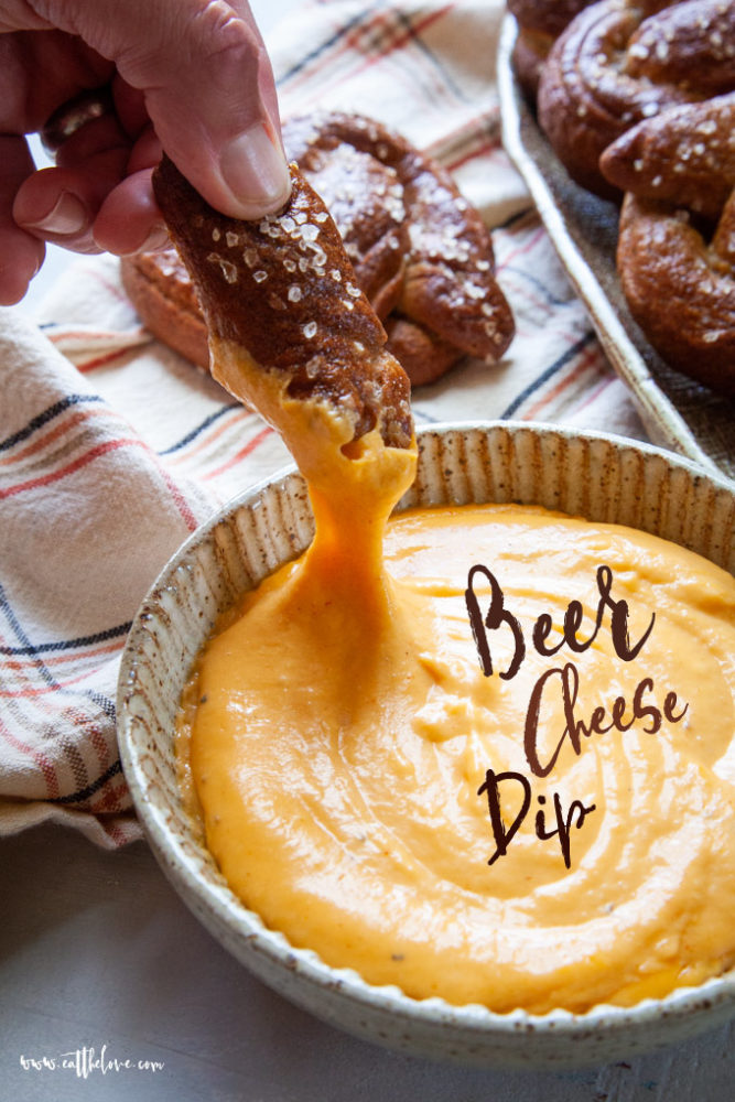 Soft Pretzel being dipped into Beer Cheese Dip