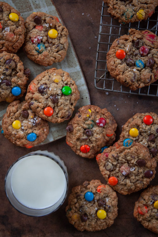 The best monster cookies on a table with a glass of milk.