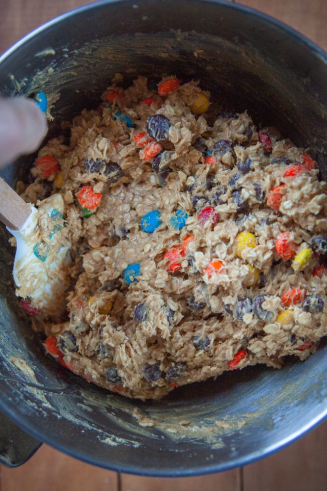 Hand mixing in chocolate chips, M&M and Reese's Pieces into the monster cookie dough.