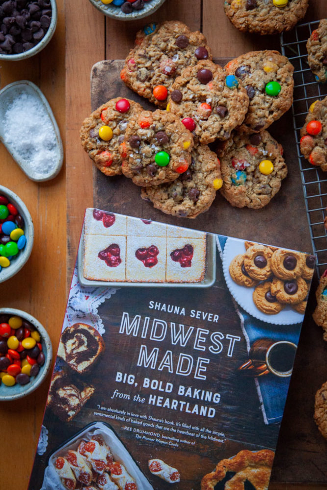 Monster Cookies and ingredients for monster cookies surrounding the cookbook Midwest Made which this recipe is adapted from.