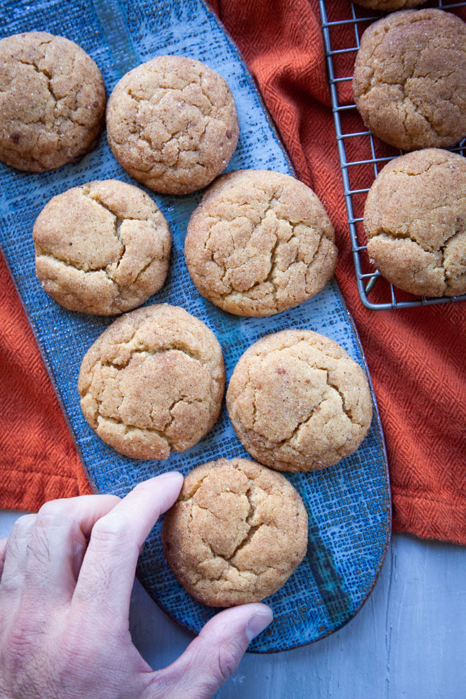 a hand reaching for pumpkin snickerdoodles.