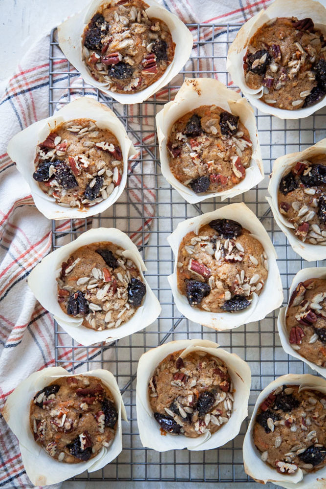carrot muffins with prunes, sunflower seeds and pecan cooling on a wire rack.