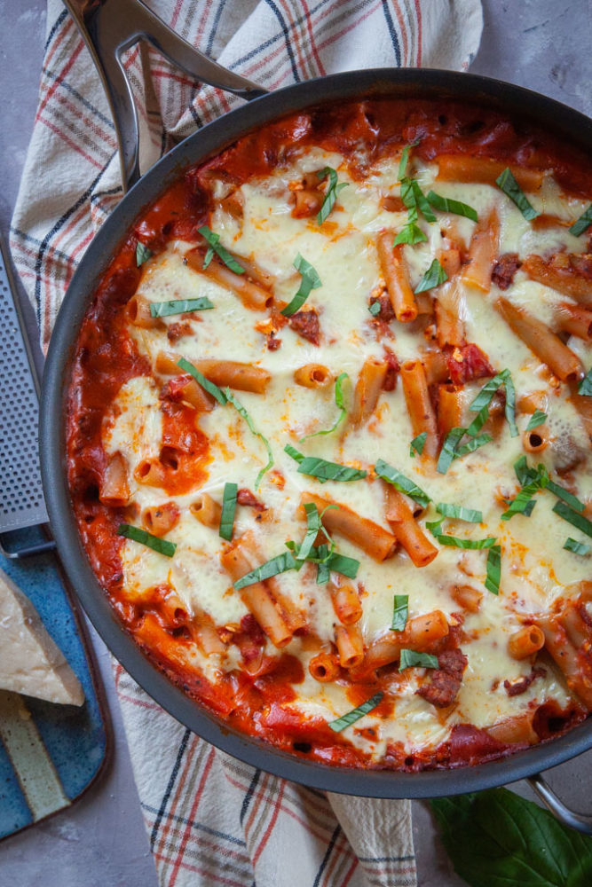 Easy skillet pasta in the skillet with a wedge of parmesan on the side.