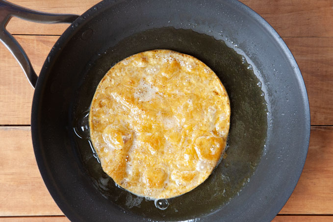 Fry tortilla until it starts to crisp but doesn't turn completely hard.