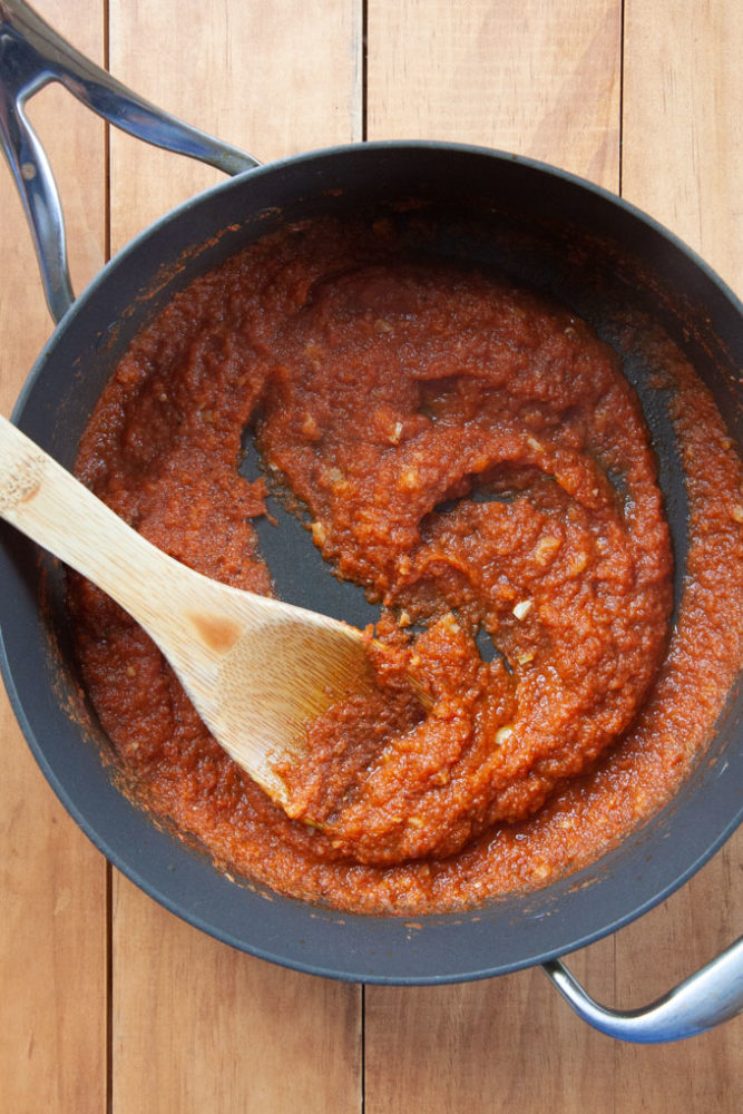 Reduce the salsa for the Huevos Rancheros in a pan.
