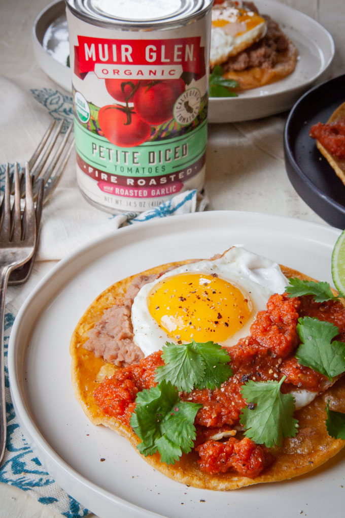 Huevos Rancheros (rancher egg tacos) on plates with a can of Muir Glen petite diced tomatoes next to the plate.