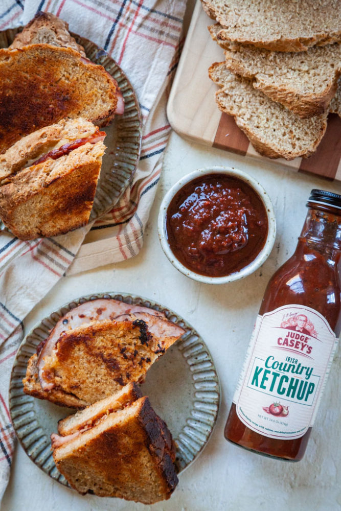 Ham and Cheese toastie sandwiches on plates, next to Irish Country Ketchup.