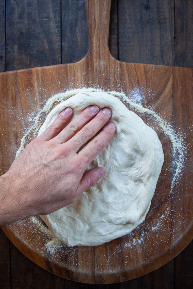 Stretching the dough on a pizza peel.