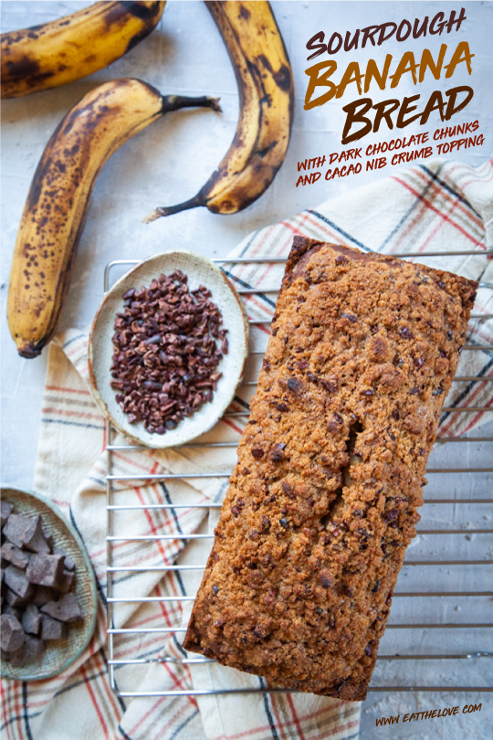 Sourdough banana bread on a cooling rack, surrounded by the ingredients for the recipe.