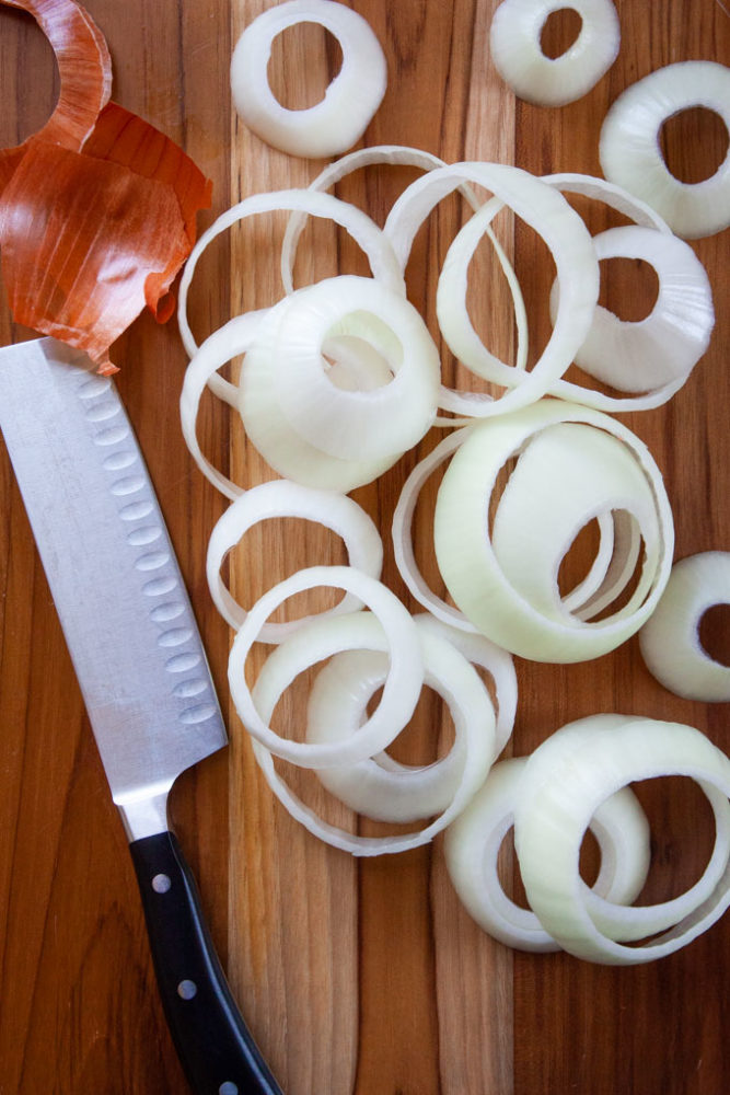 Sliced onions on a cutting board.