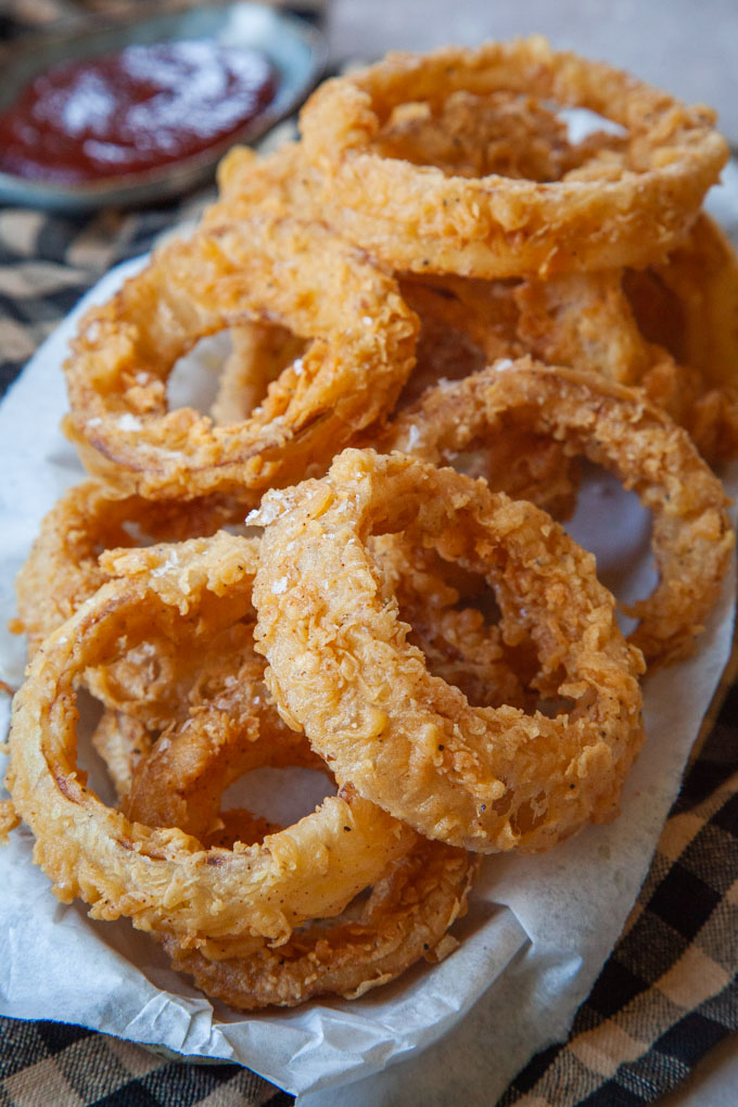 Sourdough onion rings piled up on a plate.