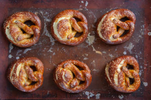 Soft sourdough pretzels on a baking sheet.