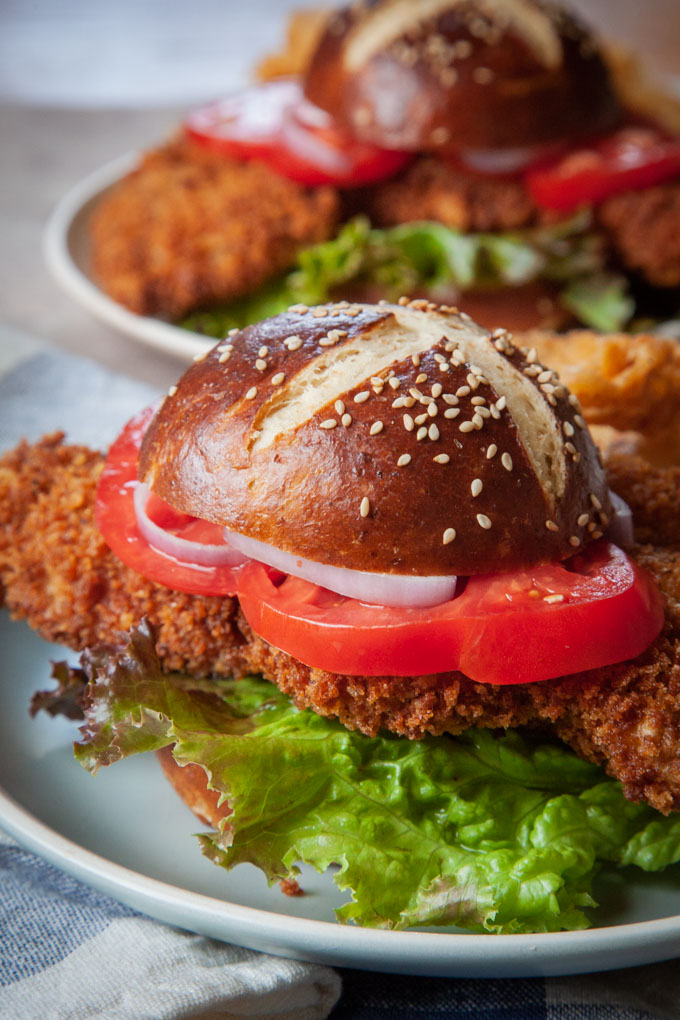 Pork tenderloin sandwiches with pretzel buns on plates