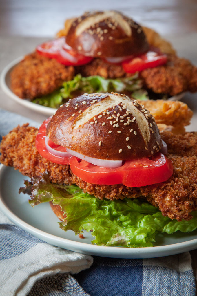 Pork tenderloin sandwiches with pretzel buns on plates