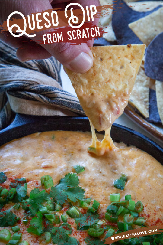 A chip being dipped into some homemade queso cheese dip.