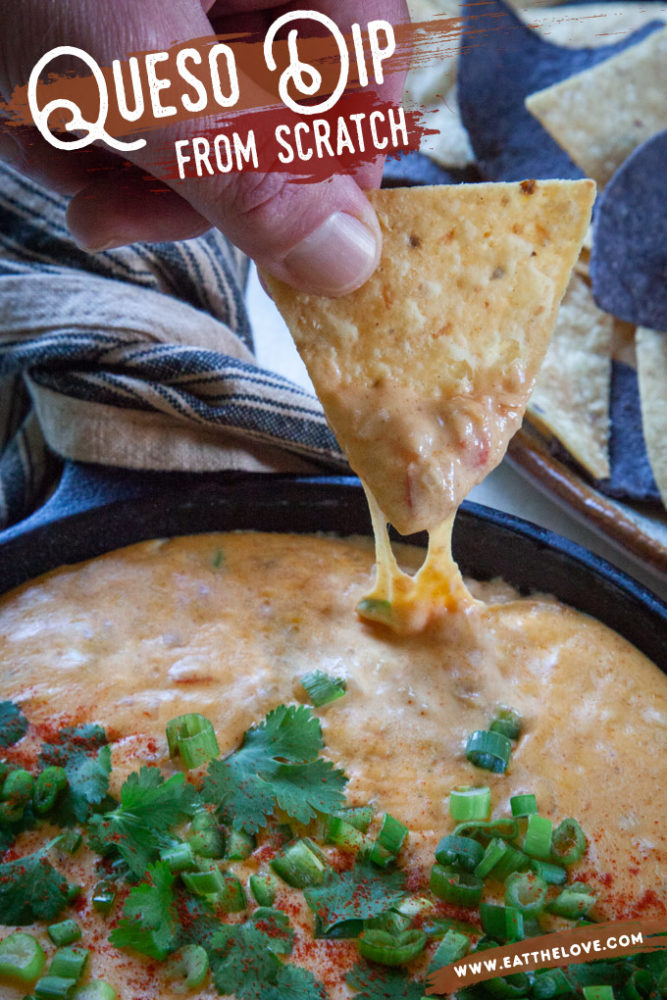 A chip being dipped into some homemade queso cheese dip.