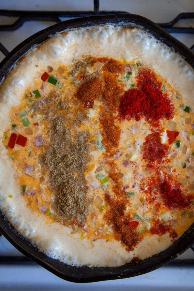 Spices added to bubbling queso.