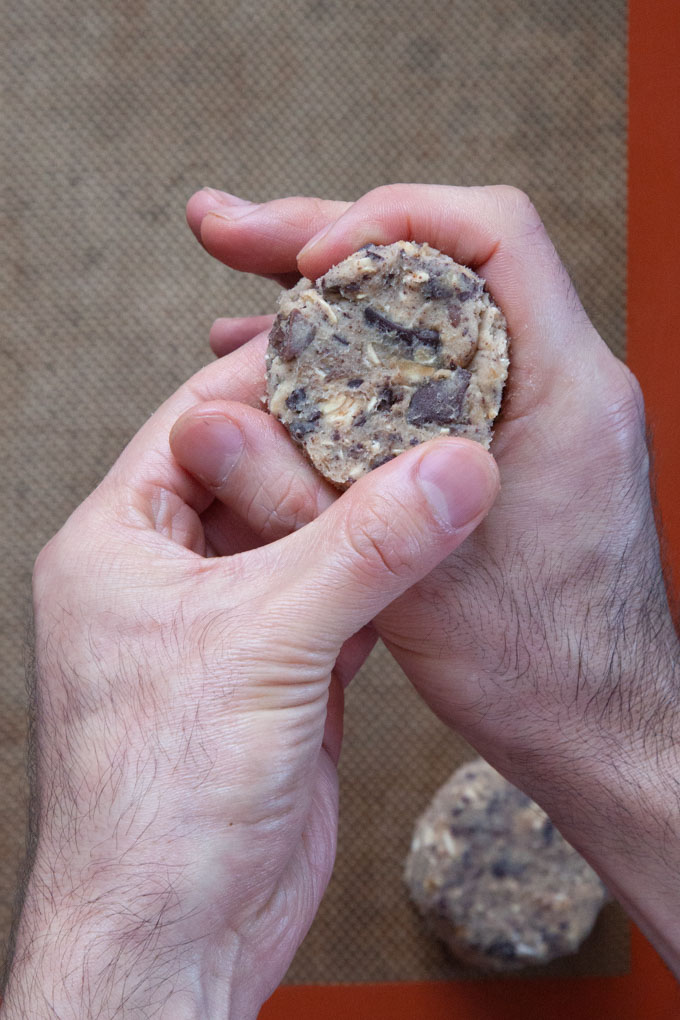 Hands forming the cookie dough disks.