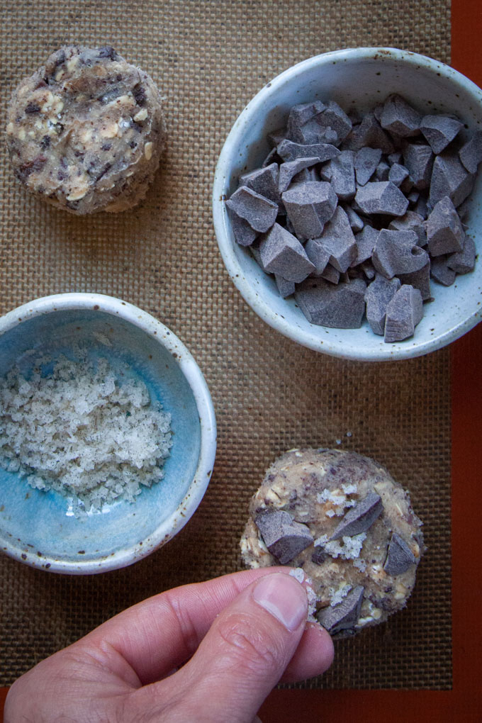 a hand sprinkling salt on top of cookie dough before baking it.