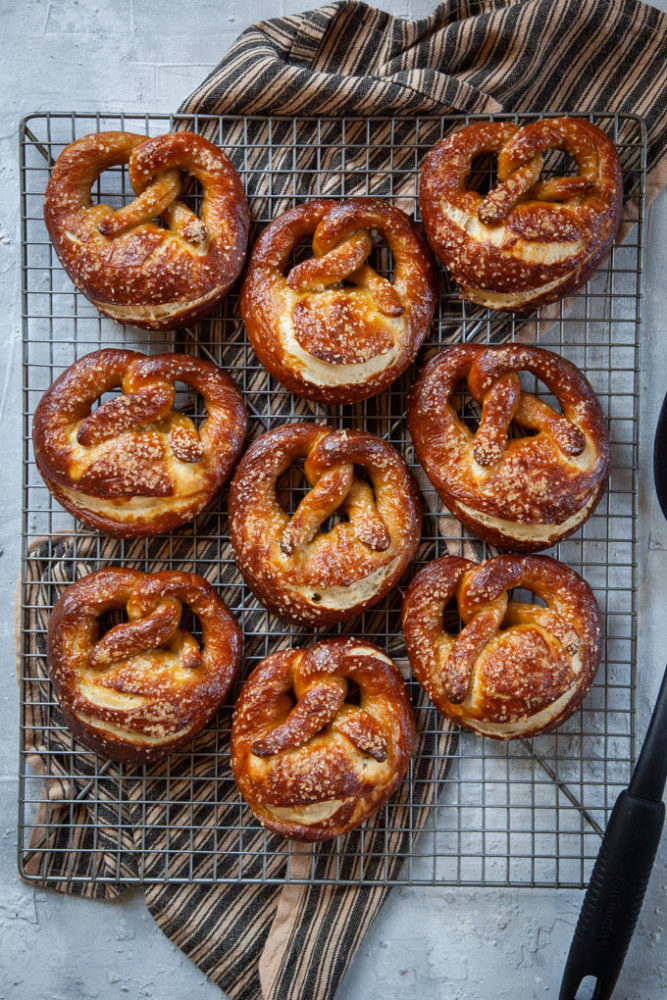 Sourdough pretzels cooling on a wire rack.