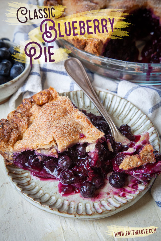 a slice of blueberry pie on a plate, next to the remaining blueberry pie.