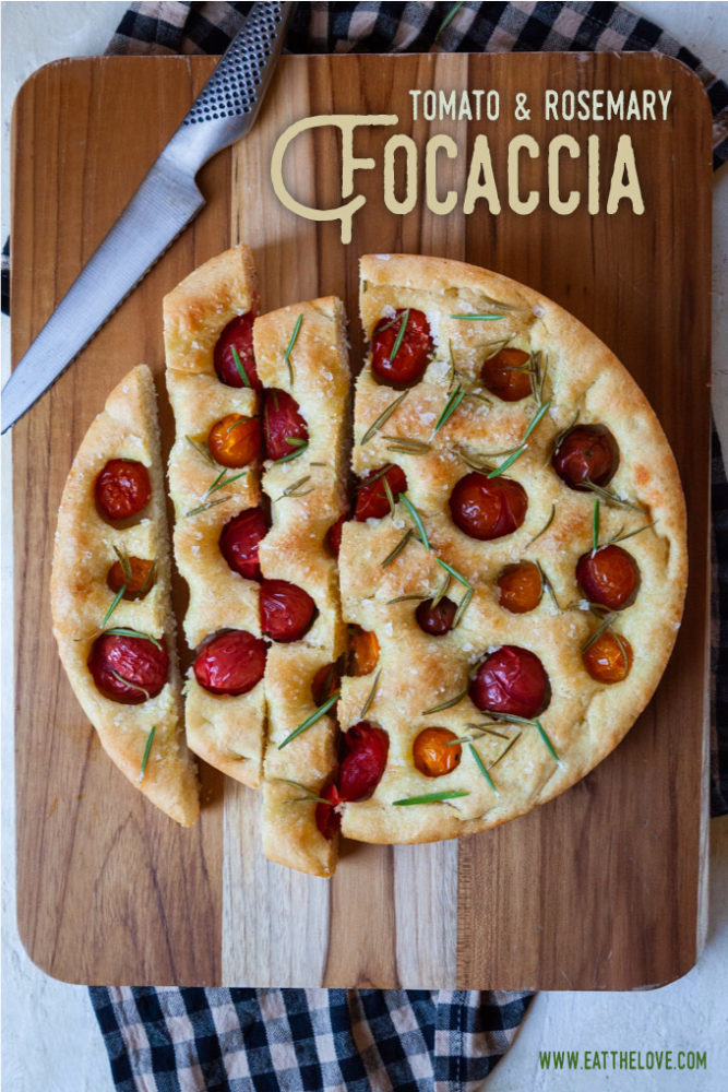 Cherry Tomato and Rosemary Focaccia sliced up on a cutting board.