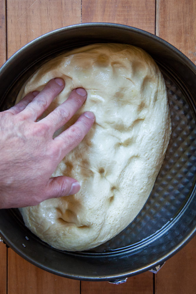 Pressing the focaccia dough out into the pan.