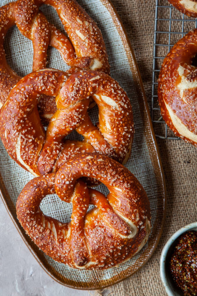 three Bavarian pretzels on a plate.