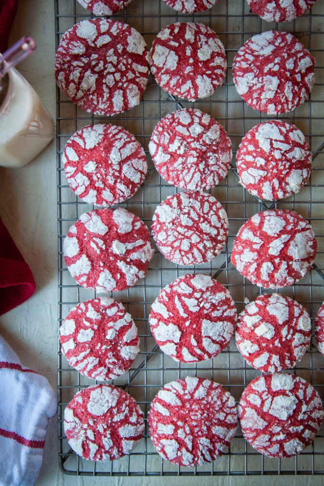 A wire cooling rack filled with red velvet crackle cookies.