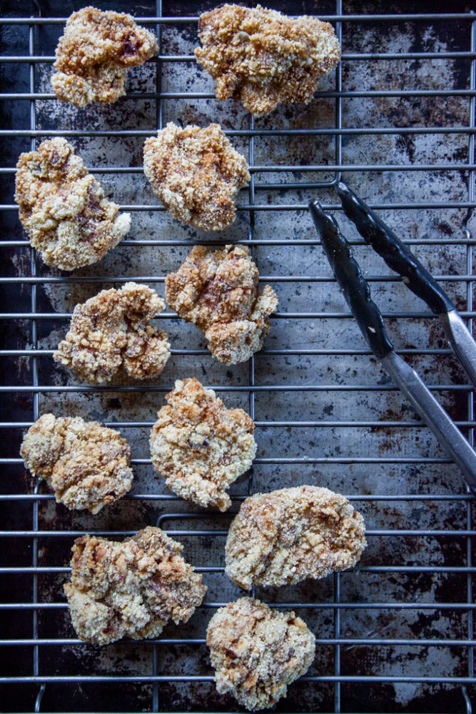 Just fried Taiwanese fried chicken on a wire rack draining, with tongs next to the pieces.