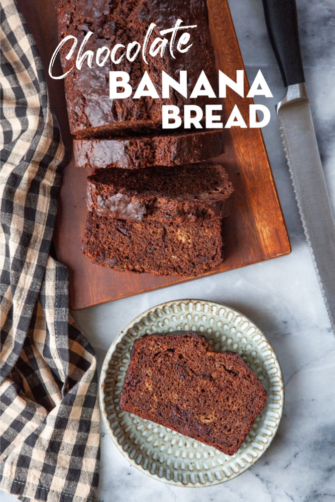 A slice of chocolate banana bread on a plate with more banana bread on a cutting board next to it.