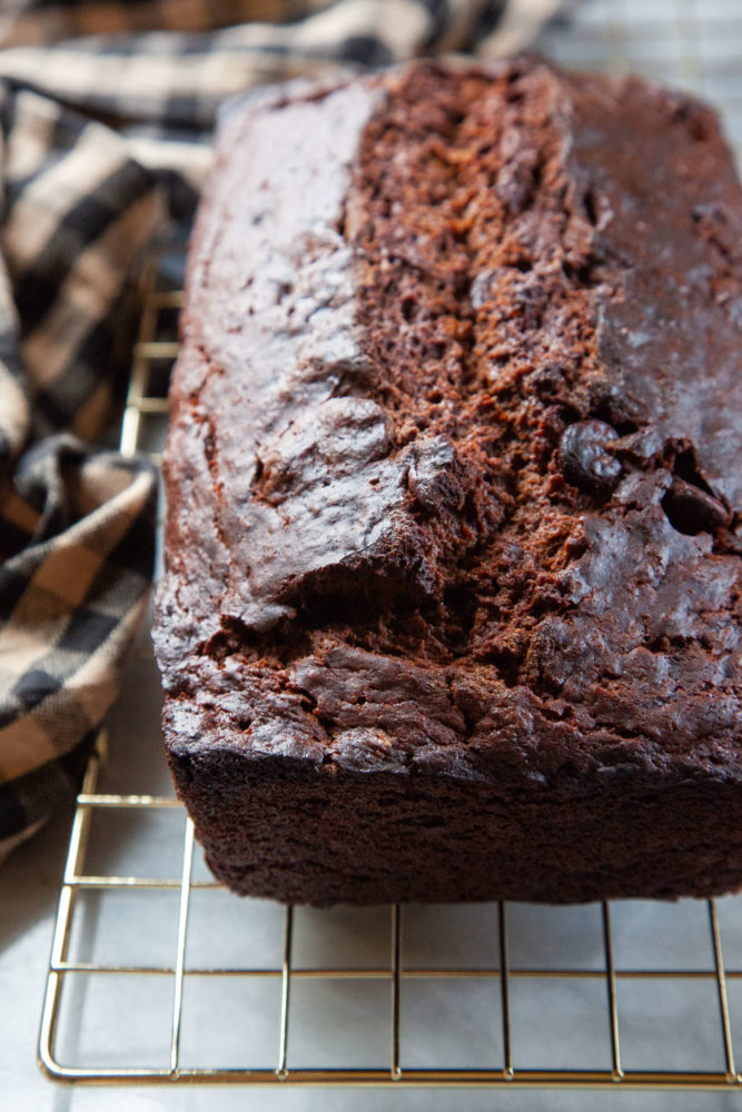 A loaf of chocolate banana bread cooling on a wire rack.