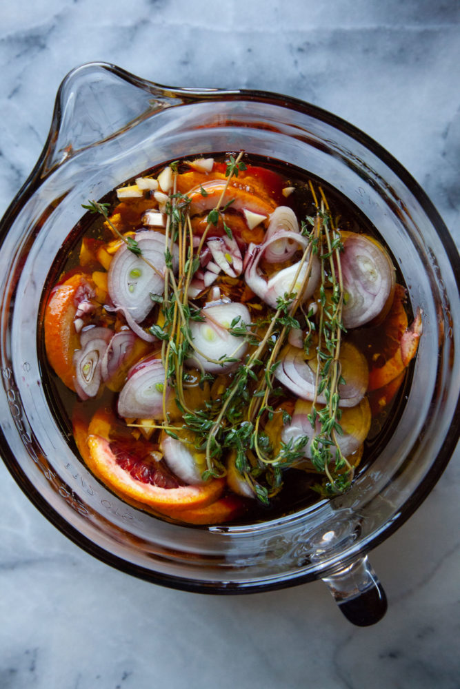 Marinade ingredients for sangria-inspired steak marinade in a glass bowl with a pour spout.