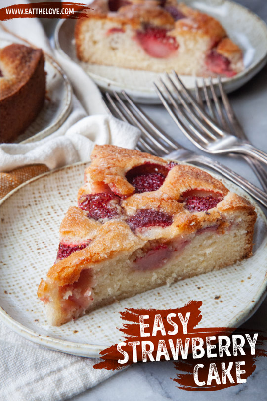 A slice of strawberry cake on a plate, with more slices of cake behind it.