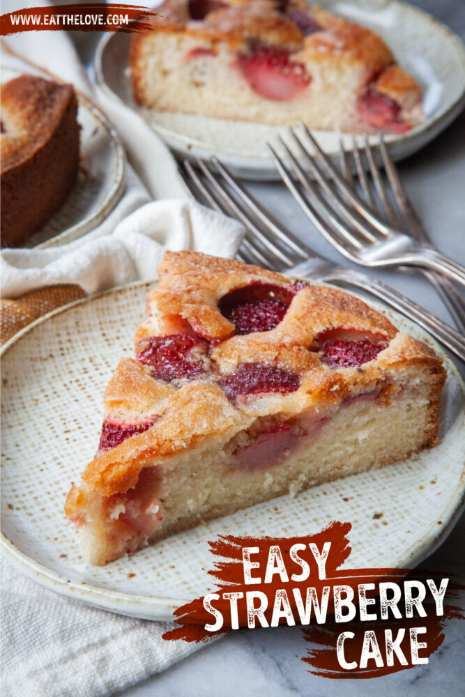 A slice of strawberry cake on a plate, with more slices of cake behind it.