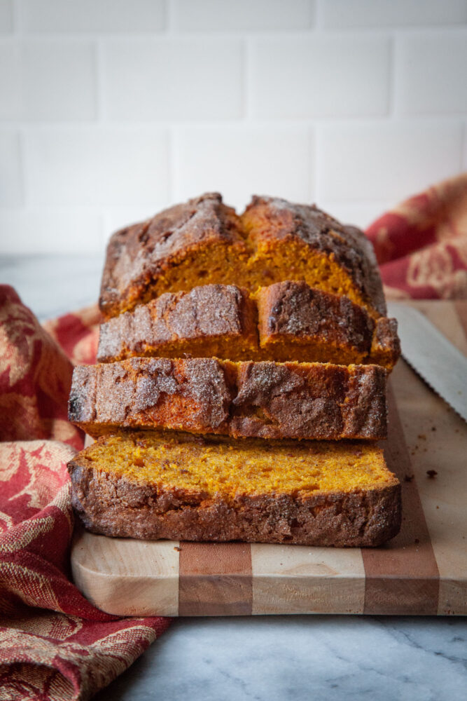 Sliced pumpkin bread on a cutting board.