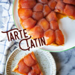 Tarte Tatin on a serving platter, with a slice of tarte tatin on a small plate next to it.