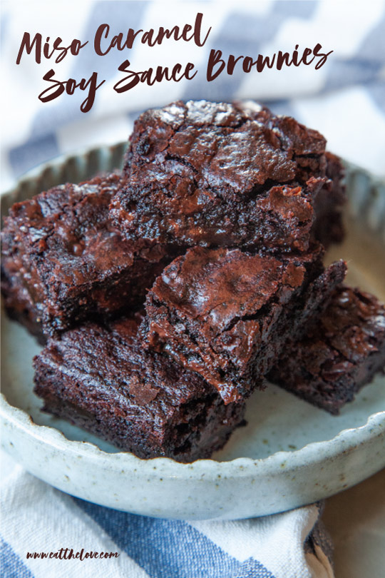 A small plate of miso caramel soy sauce brownies. The plate is sitting on a blue and white striped napkin.